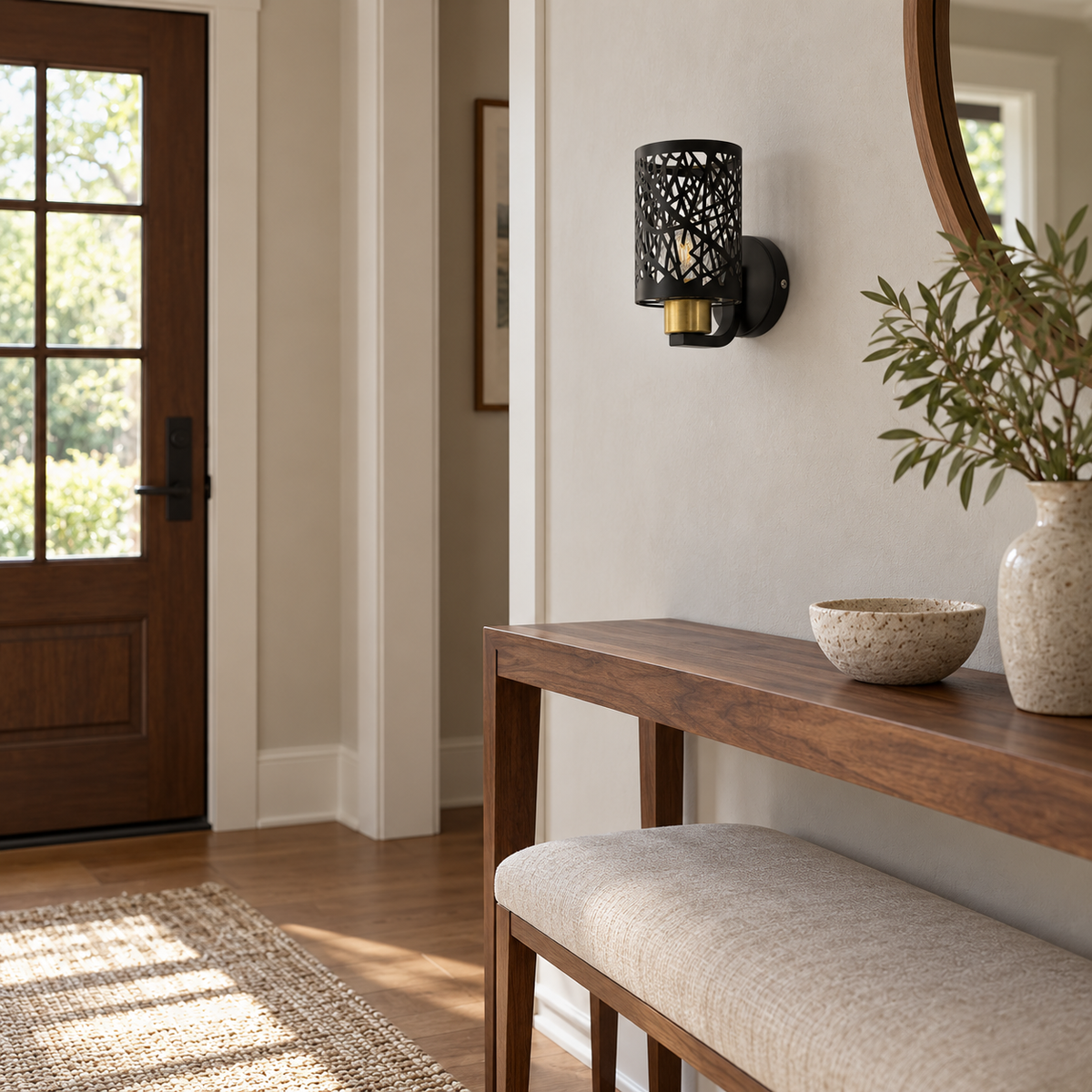 Black Lattice Cylinder Wall Light above a console and upholstered bench beside an entry door in daylight, switched off