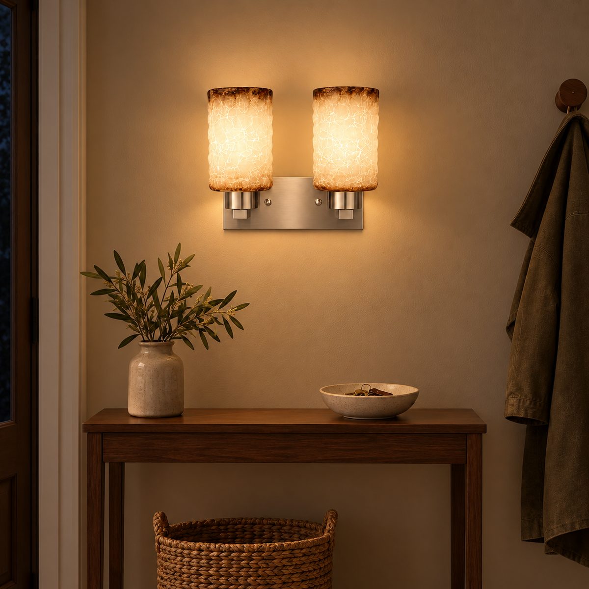 Twin Crackle Shade Satin Wall Light above a wood console beside a hanging coat at night, illuminated