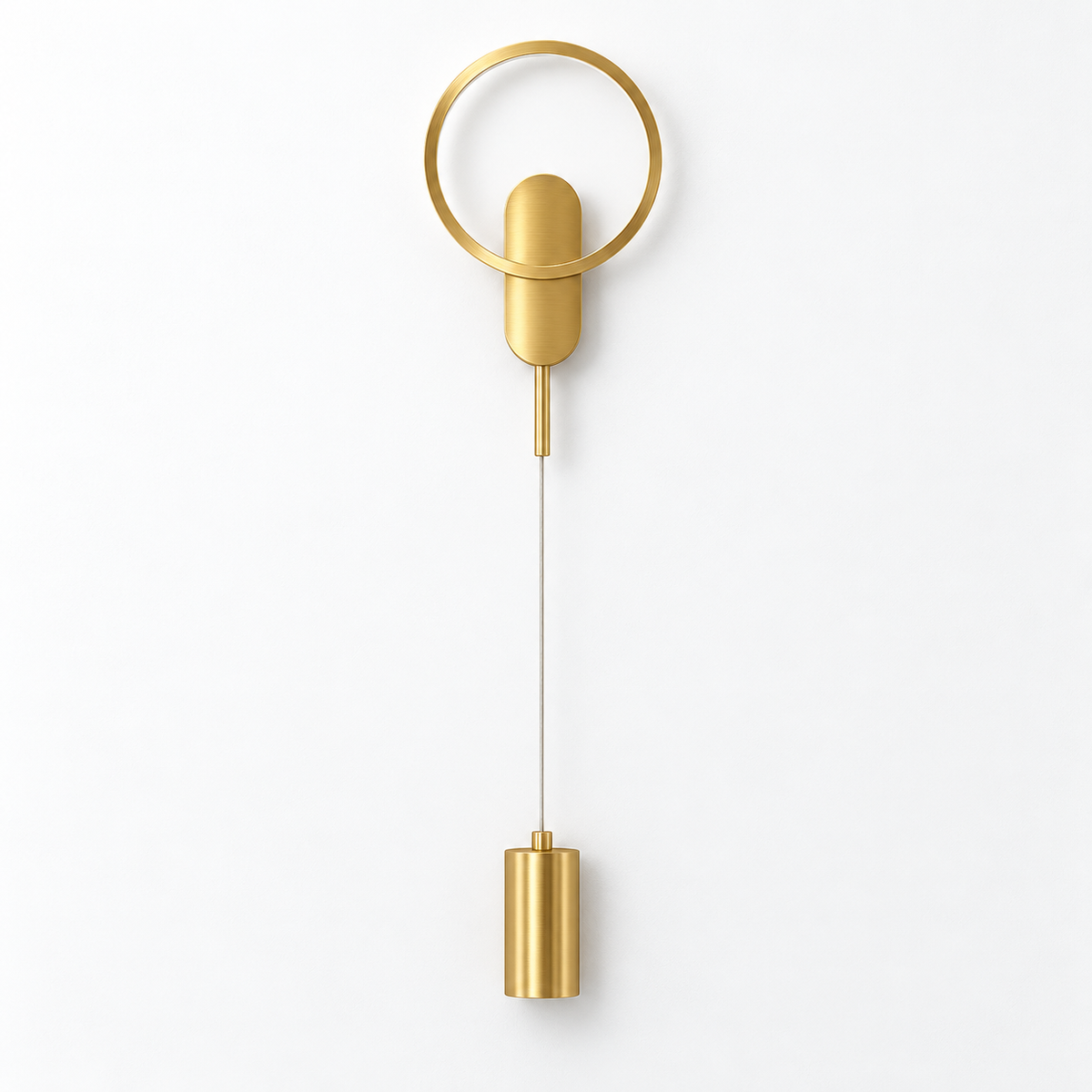 Gold-toned wall light with an upper circular halo and a small suspended cylinder below, switched off against a white studio background.