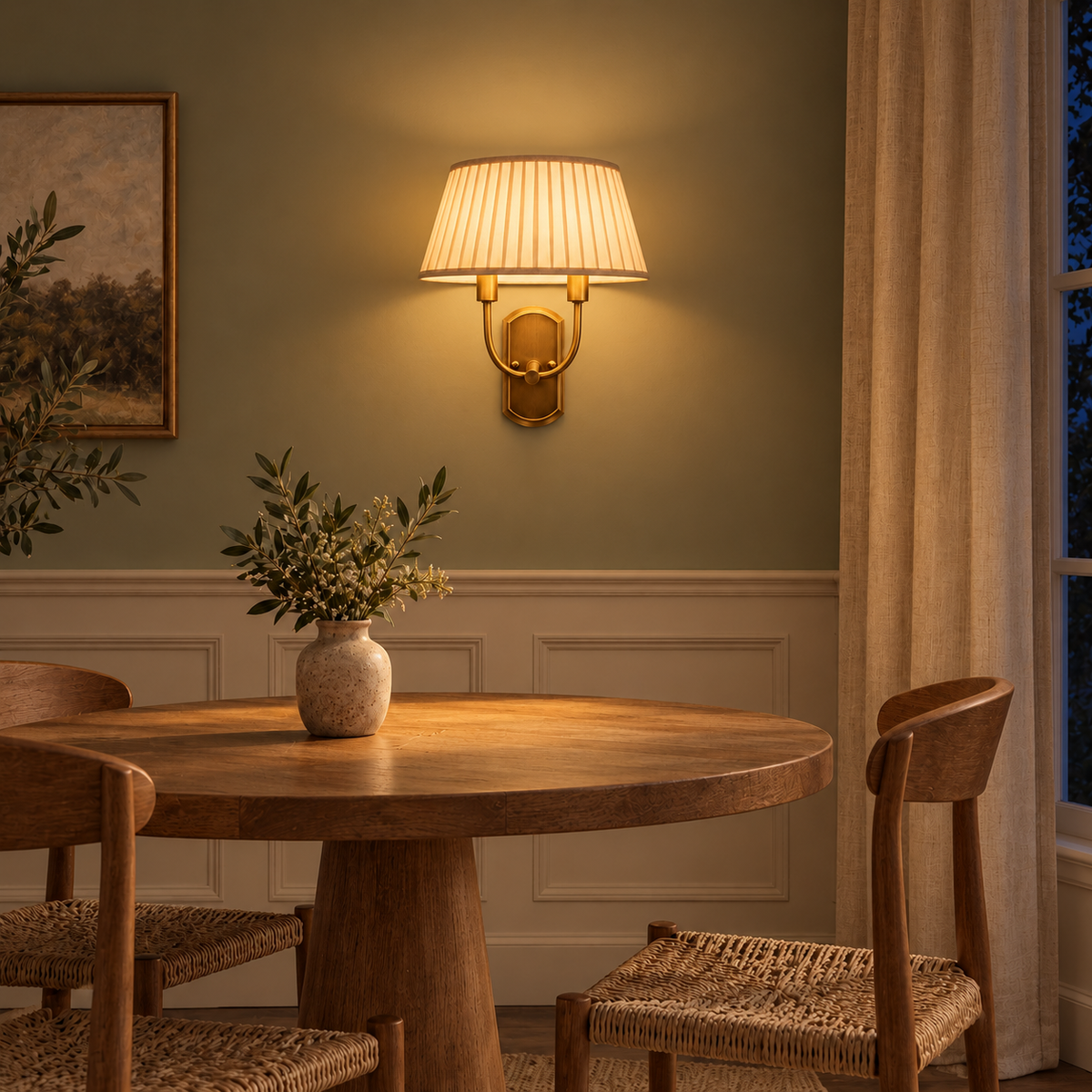 Twin Arm Pleated Shade Wall Light above a round dining table beside framed artwork at night, illuminated