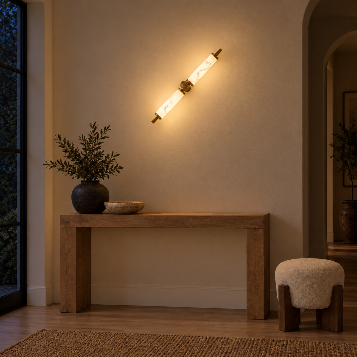 Twin cylinder marble-effect resin wall light illuminated above an oak console at night