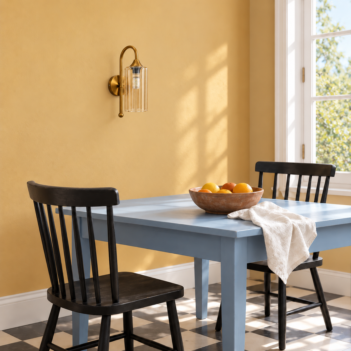 Fluted amber glass wall light above a dining table against a yellow wall in daylight, switched off