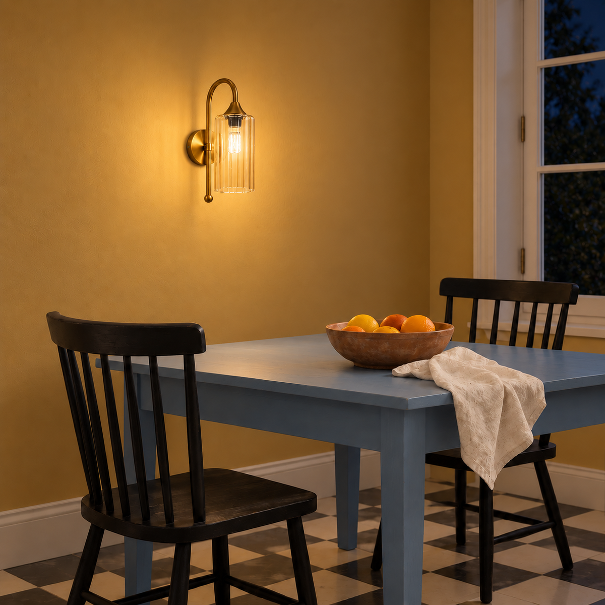 Fluted amber glass wall light illuminated above a dining table at night