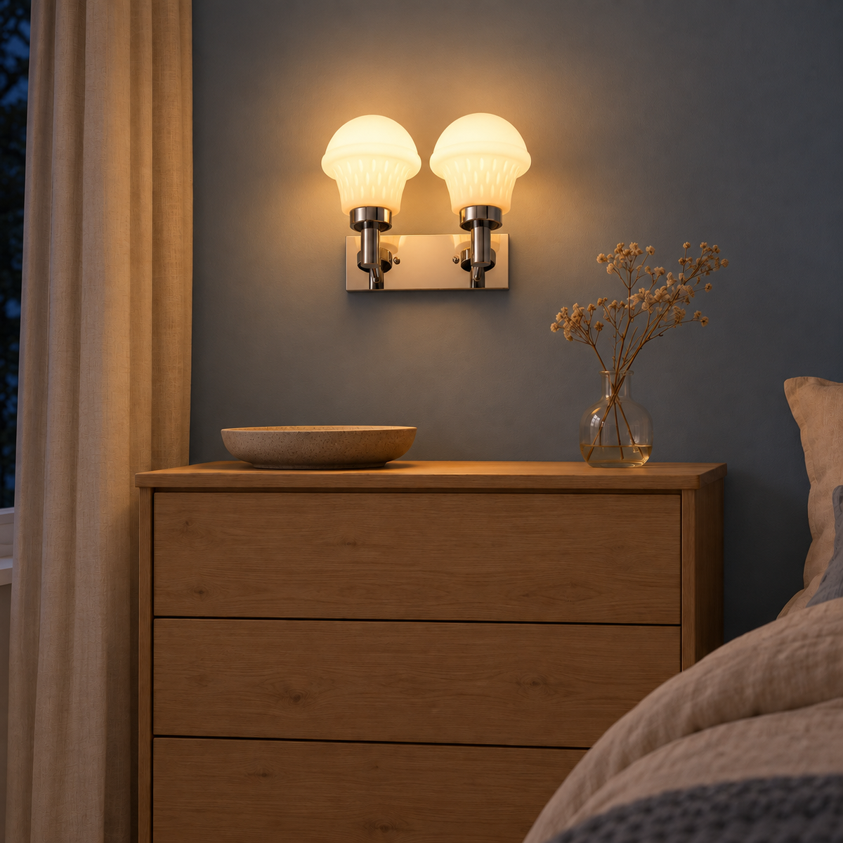 Twin Ribbed Bell Chrome Wall Light above a wood chest beside an upholstered bed at night, illuminated