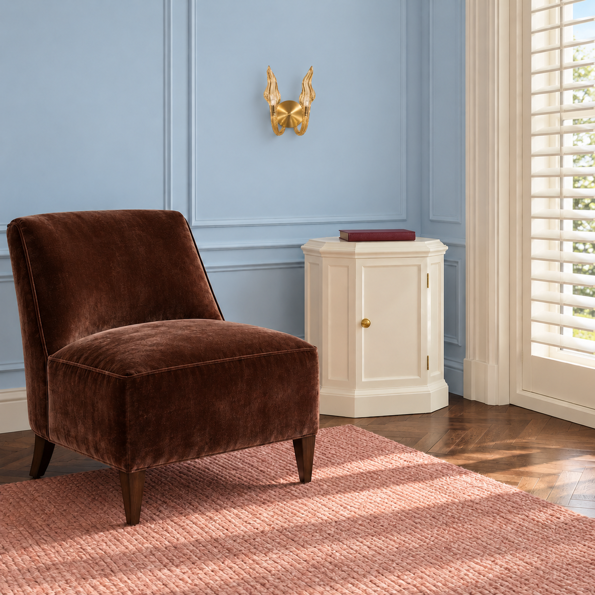 Champagne twin flame wall light beside a brown lounge chair in daylight, switched off