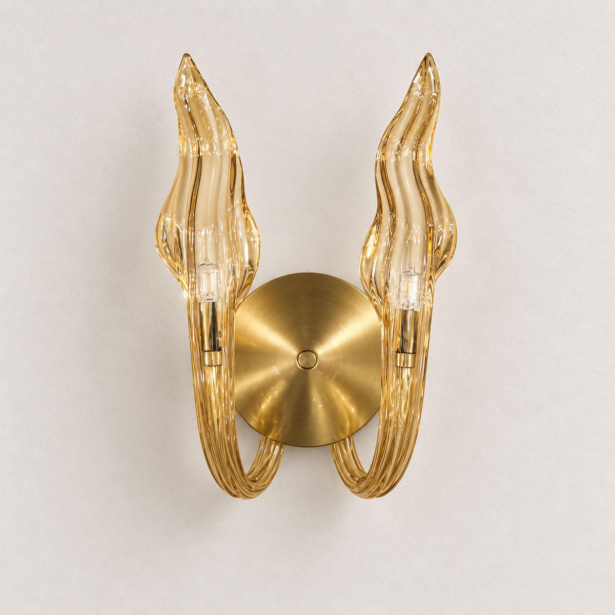 Champagne twin flame wall light with wavy upright forms, curled arms and a round backplate, switched off