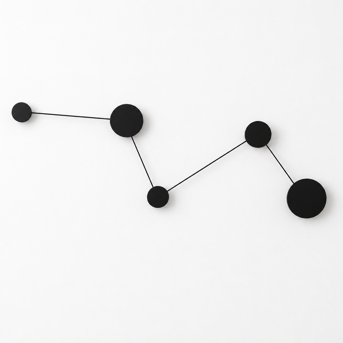 Black zigzag wall light with five linked circular plates, four rear-lit discs and one unlit end disc, switched off against a white studio background.