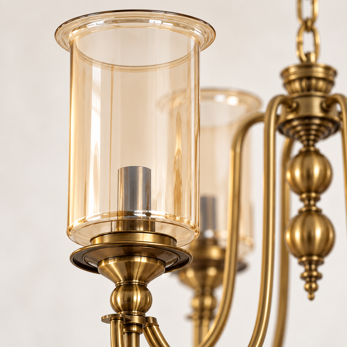 Close-up of amber cylinder glass shade and AB metal detailing