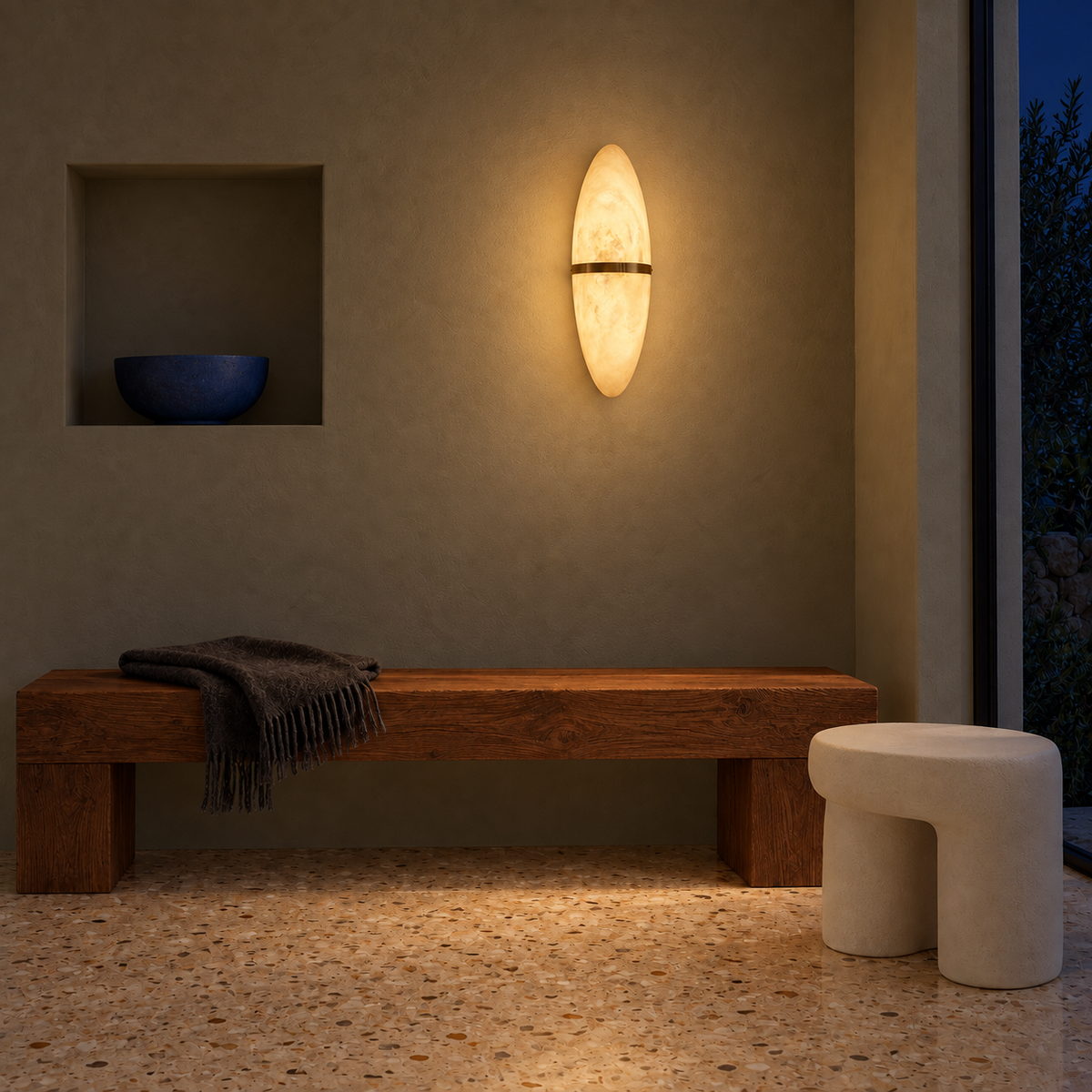 Oval stone-effect band wall light illuminated above a wooden bench at night