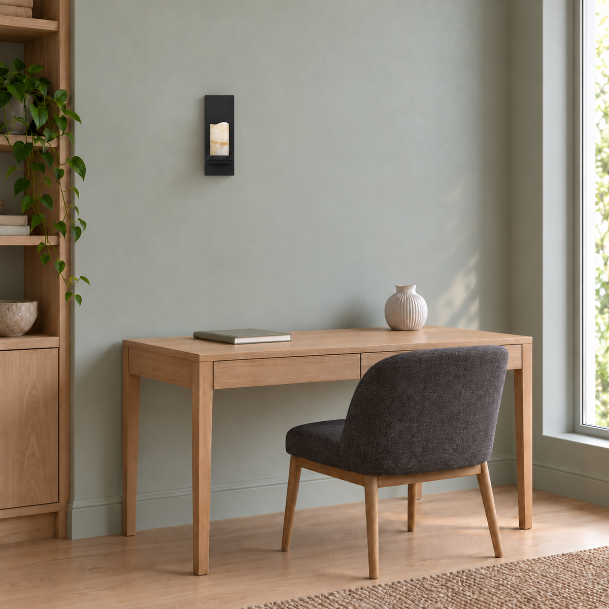 Black Plate Stone Wall Light above a light wood desk beside an upholstered chair in daylight, switched off