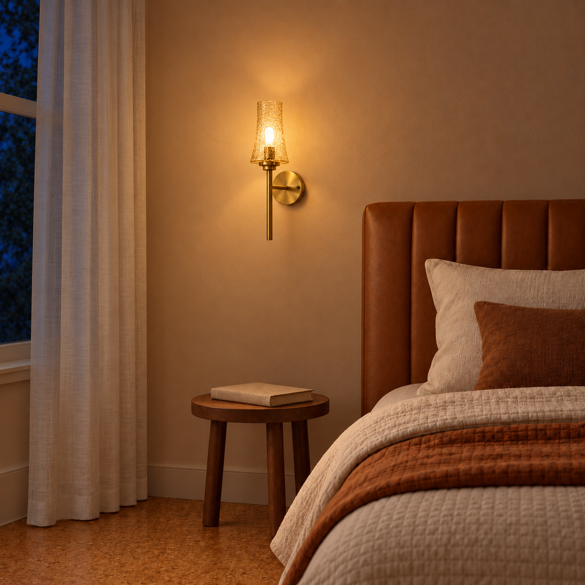 Crackle Tea Glass Torch Wall Light beside a bed above a round bedside table illuminated at night