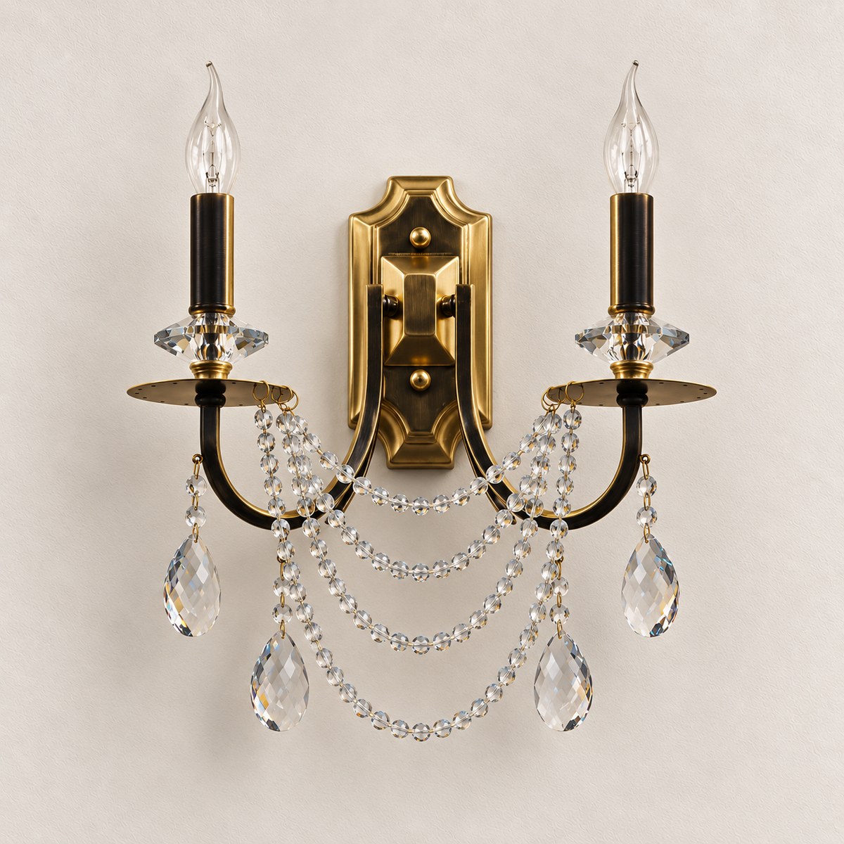 Twin candle wall light with dark curved arms, crystal garlands and teardrop pendants, switched off