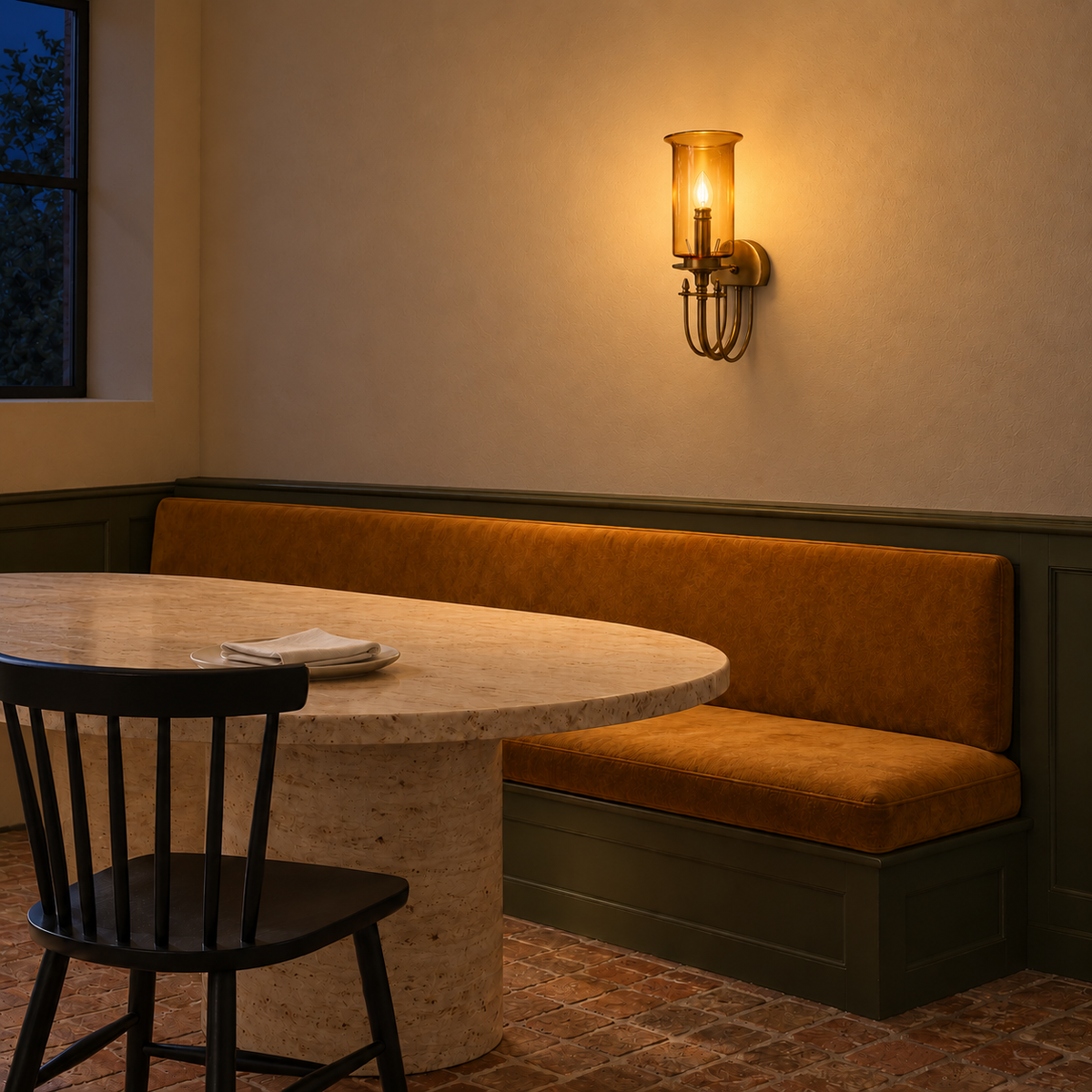 Amber Glass Hurricane Loop-Frame Wall Light above a dining banquette illuminated at night
