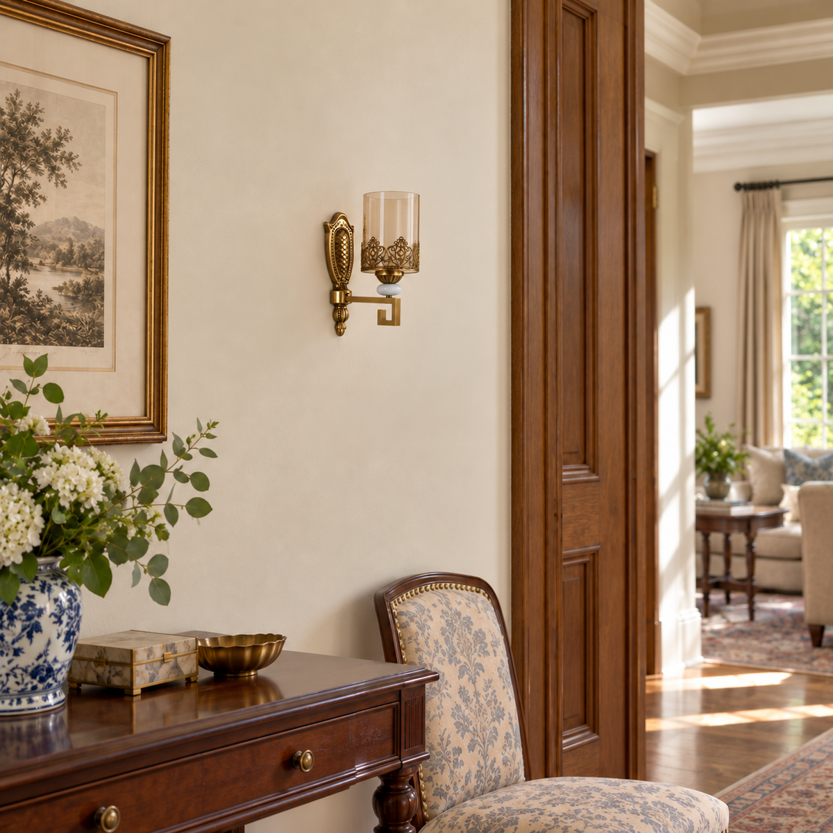 Amber cylinder filigree wall light switched off beside framed artwork and a wooden console in daylight.