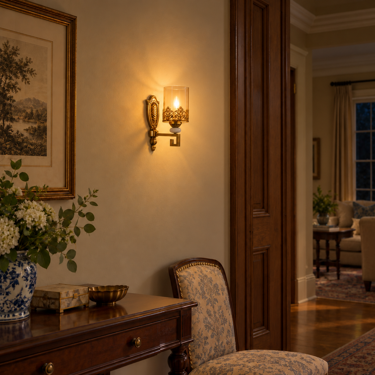 Amber cylinder filigree wall light illuminated beside framed artwork and a wooden console at night.