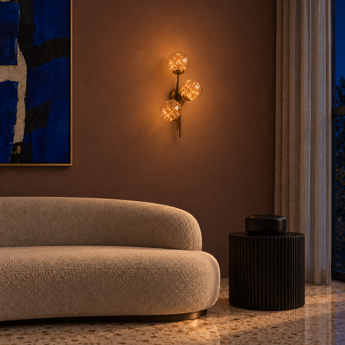 Triple Amber Glass Globe Wire-Detail Wall Light above a curved sofa beside a side table illuminated at night