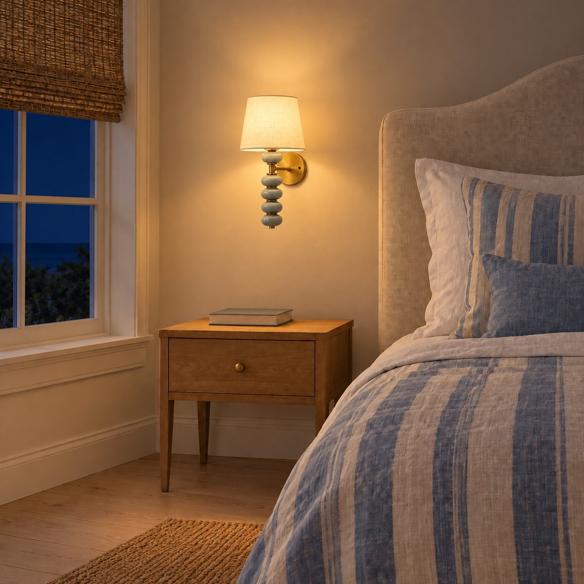 Stacked Ceramic Pebble and White Shade Wall Light above a bedside table illuminated at night