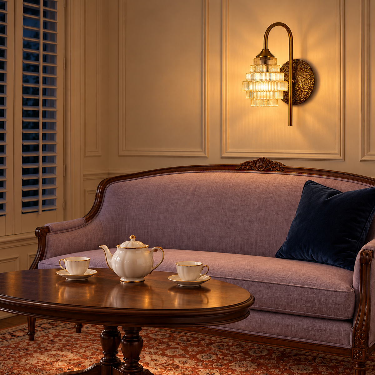 Tiered amber glass wall light illuminated above a lavender settee at night