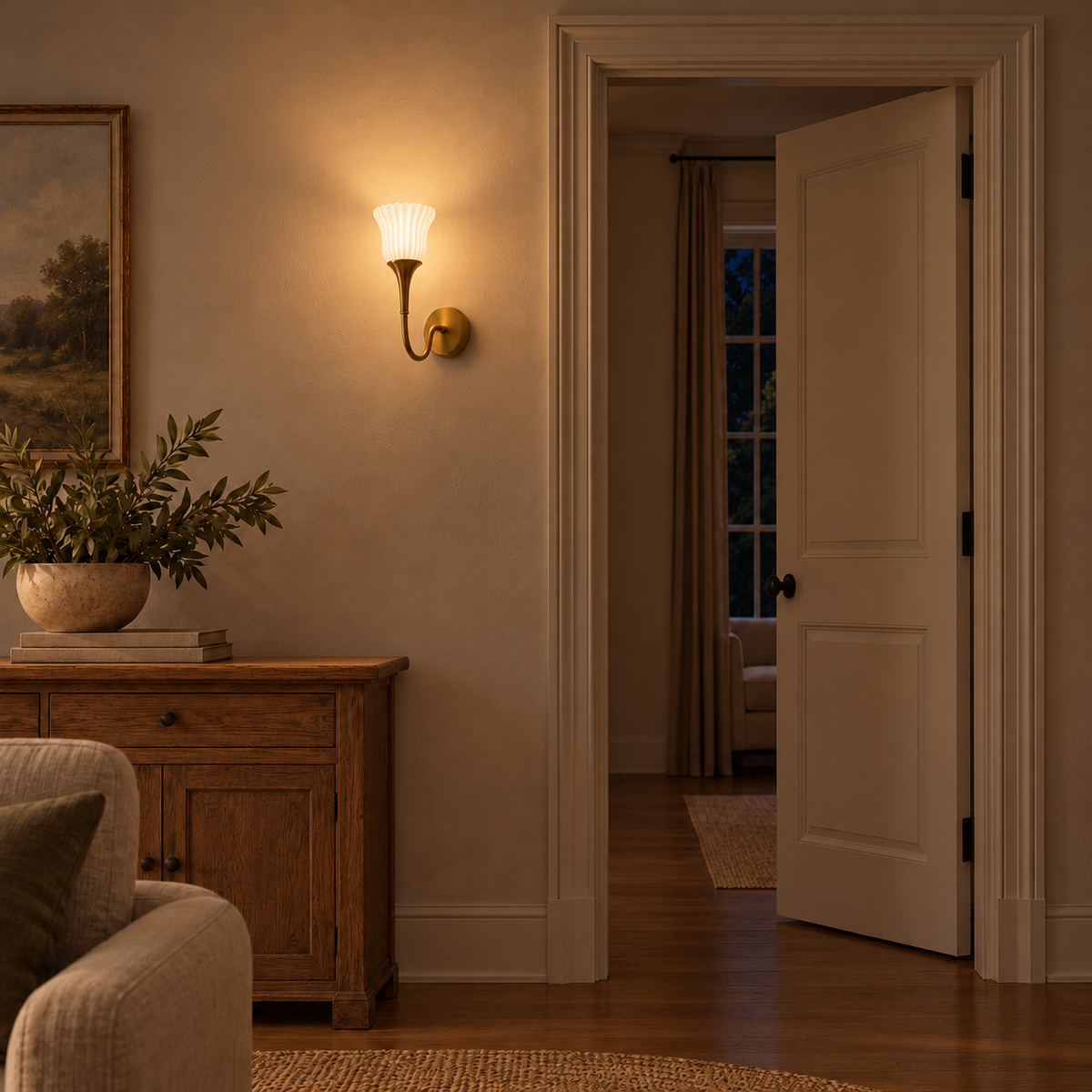 Fluted frosted glass curved-arm wall light illuminated above a carved wooden cabinet beside an open doorway at night.