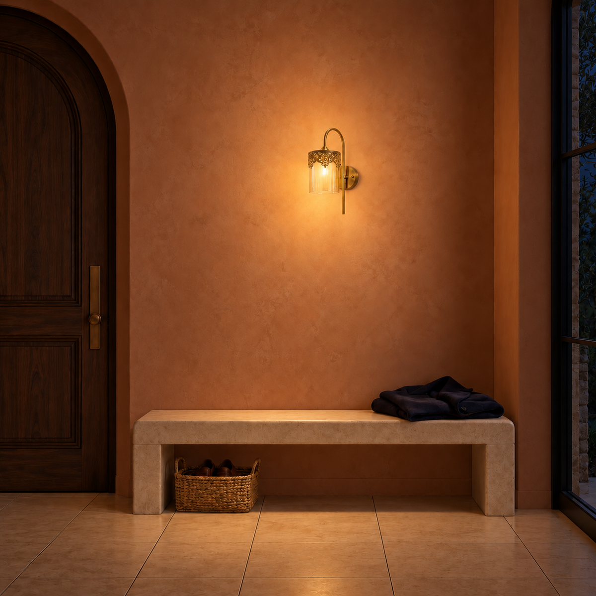 Filigree-rim glass lantern wall light illuminated above an entryway bench at night