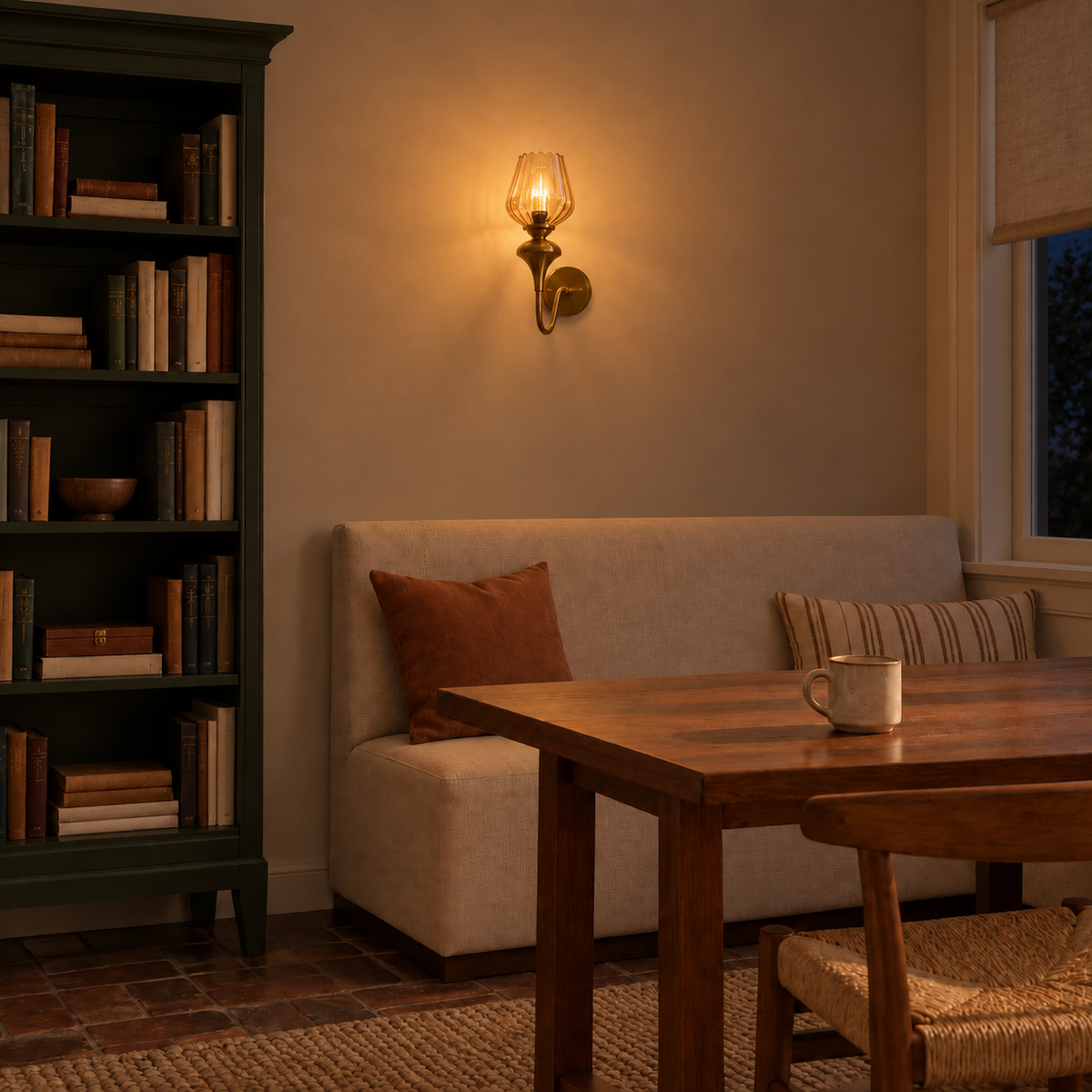 Ribbed amber glass loop-arm wall light illuminated above banquette seating at night