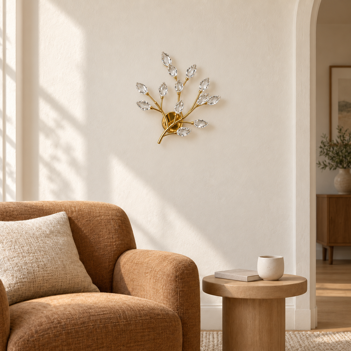 Crystal leaf branch wall light above a side table beside an upholstered armchair in daylight, switched off