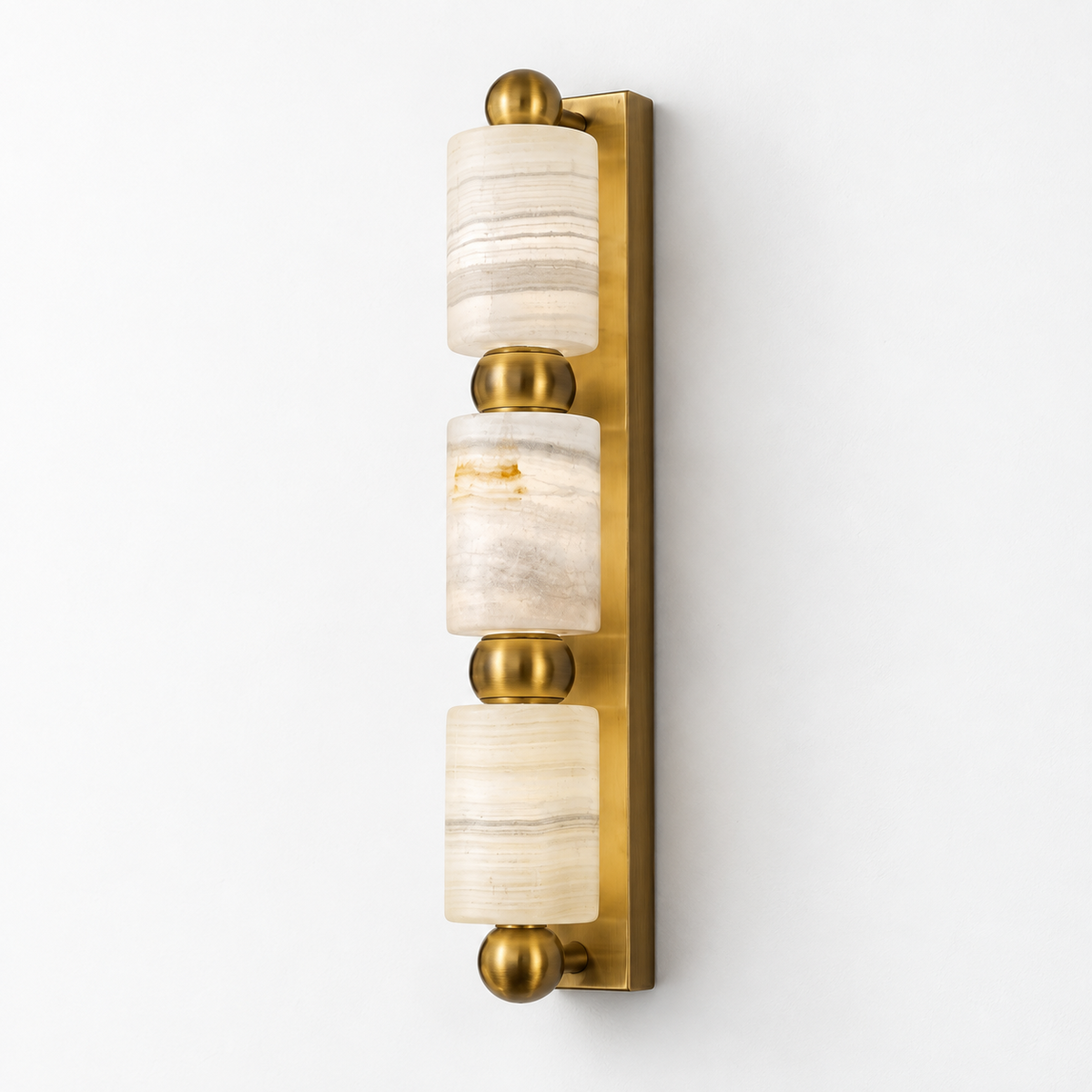 Three-cylinder marble wall light with gold finish on white background