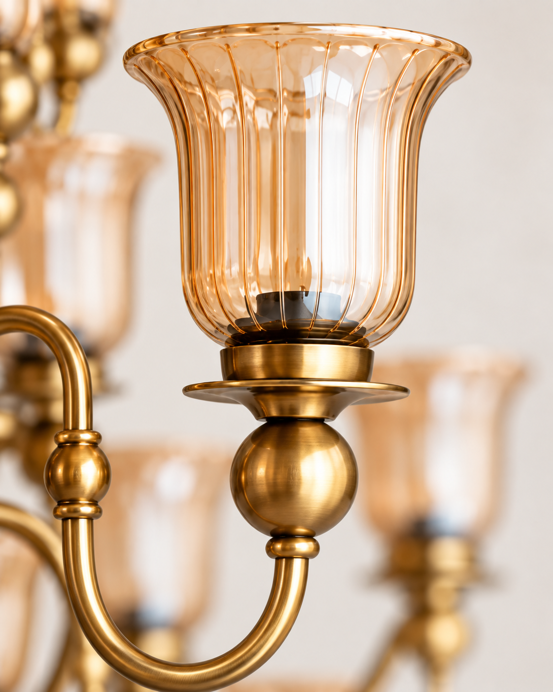 Close-up of fluted amber glass shade and AB metal detailing